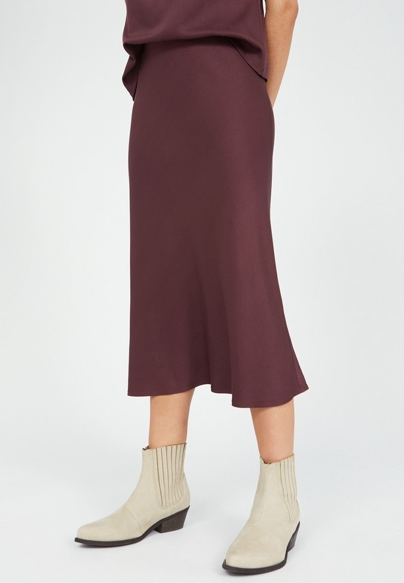 Burgundy midi-hame, jossa on liehuva helma, yhdistettynä beigeihin nilkkureihin, joissa on uritettu pinta ja matala kasa-heel.