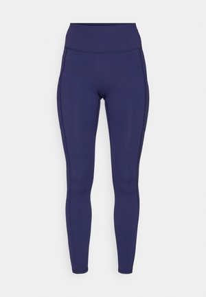 Leggings taille haute en marine fabriqués à partir d'un tissu extensible. Comprend des coutures à plat et une coupe ajustée, avec deux poches latérales pour le rangement.