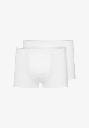 Dwie pary białych majtek bawełnianych wykonanych z miękkiego materiału. Mają gładką gumkę w talii oraz dopasowany krój z jedynym otwarciem z przodu.