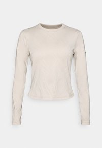 Long-sleeve top in a light beige color, featuring a textured pattern of intersecting lines, crew neckline, and slim-fit design.