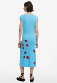Kék, közép hosszúságú ruha, rövid ujjal, piros virágzás mintával. Sima anyagból készült, enyhe fényű.