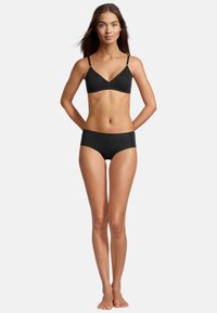 Schwarzes, nahtloses Lingerie-Set, das einen BH mit dünnen Trägern und einen passenden hochgeschnittenen Slip umfasst. Beide Teile zeichnen sich durch eine glatte Textur aus.