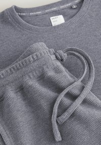 Grijze geribbelde sweatshirt met een ronde halslijn, gecombineerd met bijpassende joggers met een verstelbaar trekkoord en een gestructureerde stof.