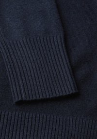 Granatowy sweter z dzianiny z bliska, o gładkiej strukturze i żeberkowych mankietach, prezentujący jednolity wzór materiału i ciemny odcień.