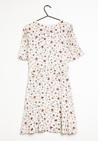 Valkoinen kukallinen mekko, jossa on levenevä helma, lyhyet hihat ja tiukka vyötärö. Mekossa on pieniä värikkäitä kukkia vaaleanpunaisena, punaisena ja sinisenä.