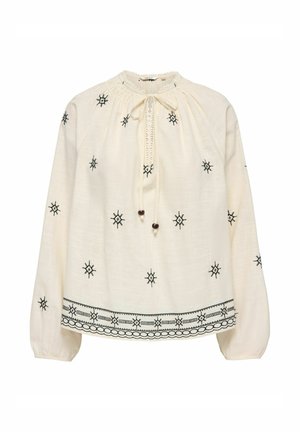 Kremowa bluzka z długim rękawem z czarnym geometrycznym haftem, dekoltem z troczkami i koralikami oraz wzorzystym dołem.