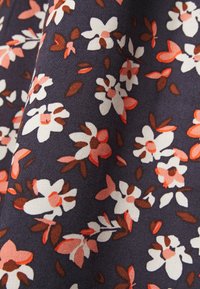 Tecido azul-marinho com um padrão floral em branco e coral, apresentando pequenas flores e folhas, com uma textura suave.