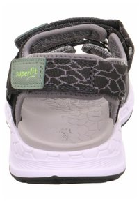 Black and gray sandals with adjustable straps, featuring a textured gray insole and a white outsole with a patterned tread for traction.