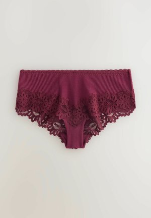 Bordeaux kantenslip met ribbeltextuur, versierd met een bloemenkant rand langs de randen en geschulpte details bij de taille.