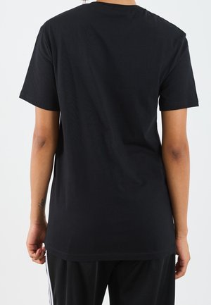 T-shirt nera a maniche corte in cotone, con scollo rotondo e vestibilità comoda, dalla texture liscia e senza motivi o accenti visibili.