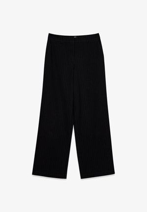 Melni plaša piegriezuma bikses ar smalkām vertikālām svītrām, jostu cilpām un priekšpuses rāvējslēdzēja aizdari, attēlotas izklātas uz baltas virsmas.