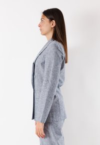 Blazer in lino grigio con un design strutturato, chiusura a un bottone e rever a punta, dotato di due tasche laterali e una trama liscia.