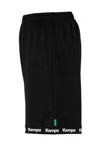 Schwarze Shorts aus glattem Stoff; mit einem elastischen Bund und dem weißen "Kempa"-Logo am Saum. Seitliche Nähte sind sichtbar.