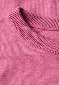 Nahaufnahme eines pinken Pullovergarns, das mit einem gerippten Halsausschnitt und weicher Textur ausgestattet ist. Es zeigt ein einheitliches Strickmuster und dezente Farbvariationen.