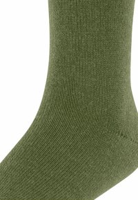 Skarpetki w oliwkowym kolorze z ryflowaną teksturą i gładkim wykończeniem, z projektem do połowy łydki i bezszwowym palcem dla wygody.