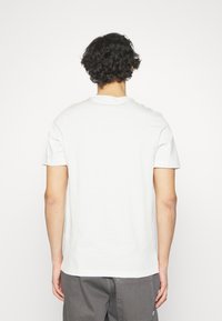 Vit bomullströja med rund halsringning och korta ärmar, med en enkel, odekorerad design och en avslappnad passform.