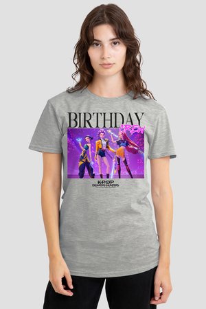Woman wearing grey T-shirt with "BIRTHDAY CREW" text and three animated female characters from K-Pop Demon Hunters on a purple background.