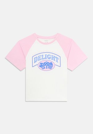 Lyhythihainen valkoinen ja vaaleanpunainen raglan T-paita, jossa on edessä "DELIGHT" ja kuppikakku grafiikka sinisessä ja vaaleanpunaisessa.