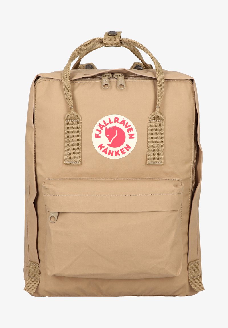Beige Fjällräven Kånken backpack with two top handles, front pocket, and a circular logo featuring a red fox. Made from durable material.