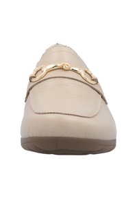Beige leren instapper met een ronde neus, voorzien van een gouden kettingaccent, een zachte textuur aan de bovenkant en een flexibele bruine rubberen zool.