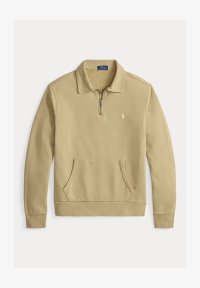 Sudadera beige con cuello de media cremallera, puños acanalados y un bolsillo tipo canguro en la parte frontal. Presenta un pequeño logo bordado en el pecho.