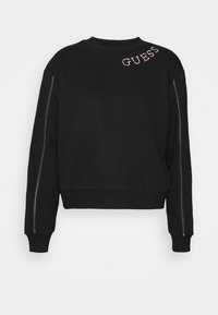 Sudadera negra de manga larga, con puños acanalados y cuello redondo. Presenta la palabra "GUESS" en strass en el frontal y detalles de cremallera plateados en las mangas.
