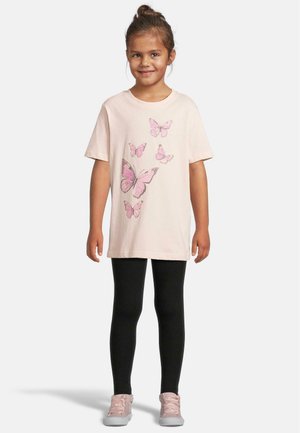 Lyse rosa t-skjorte med sommerfugl grafikk, kombinert med svarte leggings og rosa joggesko. Korte ermer, avslappet passform, glatt tekstur.