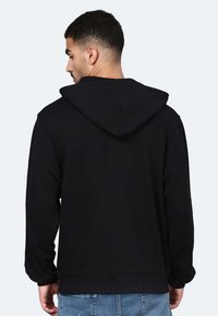 Felpa nera con cappuccio regolabile, maniche lunghe e vestibilità comoda. Realizzata in tessuto morbido, con polsini e orlo a costine.
