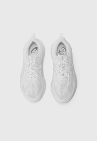 Baskets de sport blanches avec une tige en maille respirante, des lacets plats, un col rembourré et une semelle texturée pour une meilleure traction. Logo emblématique sur la languette.