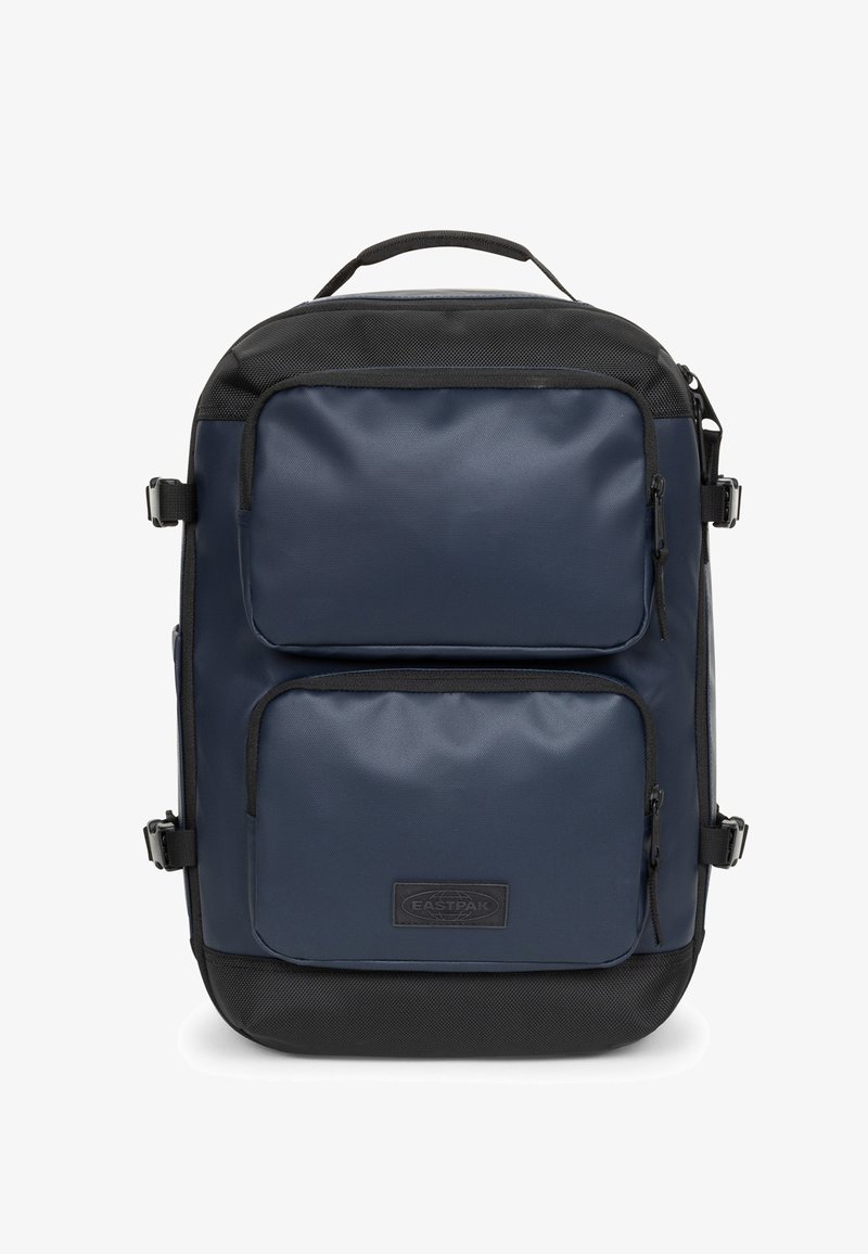 Zaino blu navy con texture liscia, dotato di due tasche anteriori con zip, dettagli neri e una maniglia superiore. Tessuto resistente e design minimalista.