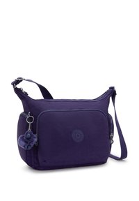 Borsa a tracolla in nylon viola con chiusura zip, tasca frontale, patch con logo e un pom-pom in pelliccia come accento. Include una tracolla regolabile.