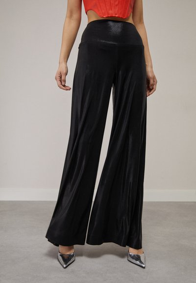 Pantalones de pierna ancha negros, hechos de un material suave y brillante. Diseño de cintura alta, con una silueta fluida y un estilo minimalista.