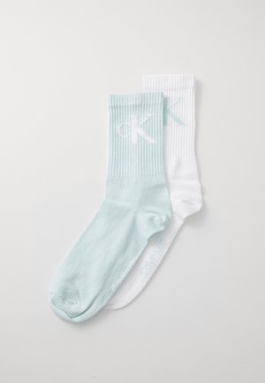 To par med sokker: en lys blå med ribbestrikket topp som har en hvit "CK"-logo, og en hvit med ribbestrikket topp og matchende logodetalj.