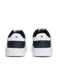 Granatowe skórzane buty sportowe z białymi akcentami, charakteryzujące się gładkim wykończeniem, wyściółką w kołnierzu i białą podeszwą z logo. Widoczny detal z logo.