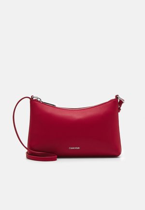 Borsa a tracolla in pelle rossa con finitura liscia, chiusura con zip e tracolla regolabile. Presenta un logo metallico sulla parte anteriore.