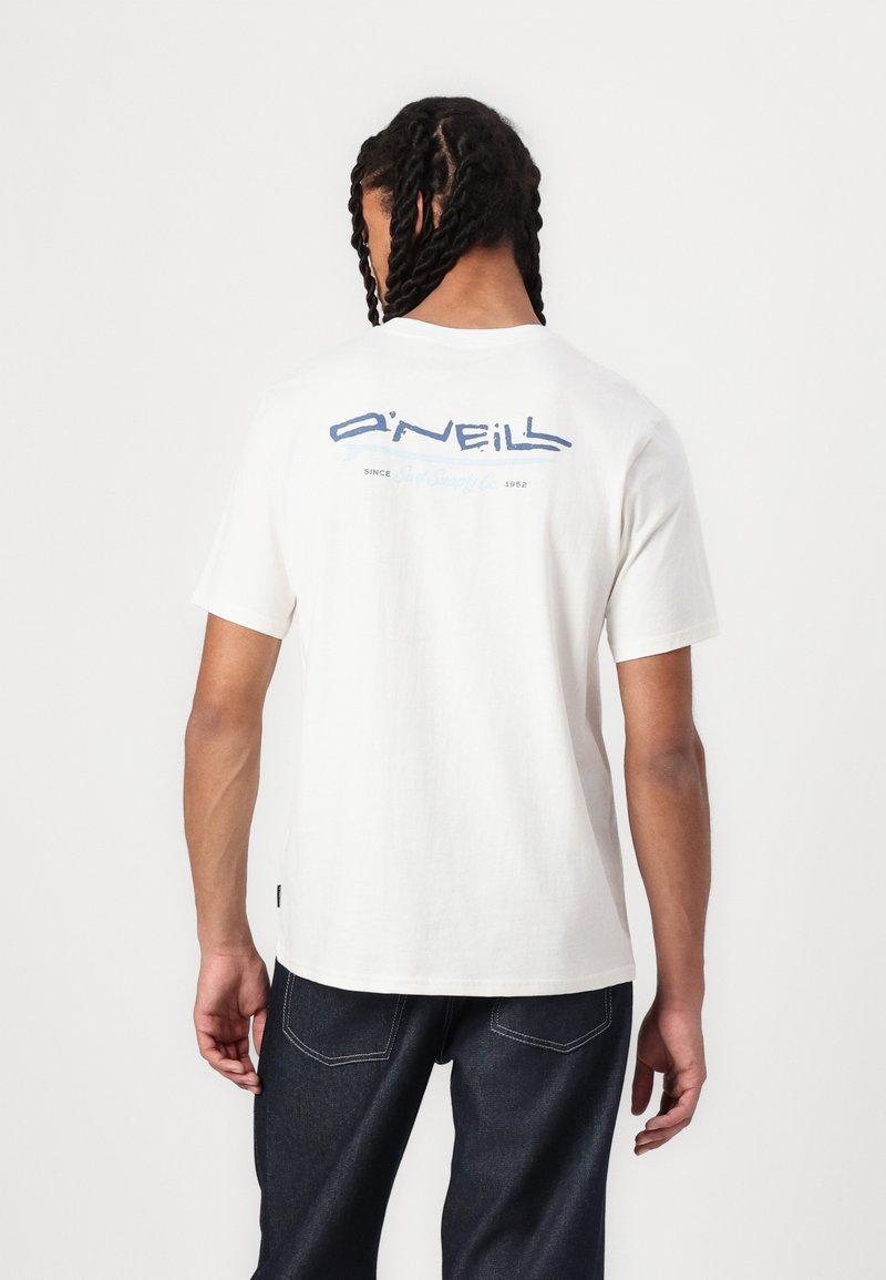 Hvid bomulds t-shirt med et blåt grafisk logo på ryggen, korte ærmer og en afslappet pasform. Sammen med mørkeblå denim jeans.