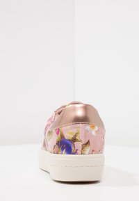 Rosa blommig sneaker med klack i metallisk roséguld. Har ett invecklat mönster av blommor och en vit gummisula.