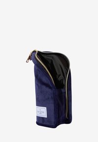Marineblå suedepose i cylindrisk form med guld lynlås og sort indvendigt. Har et eksternt mærke med teksten "THE FLAT LAY CO. LONDON".