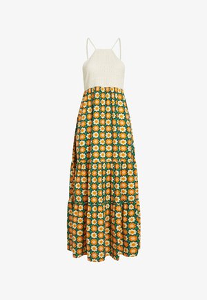 Robe à bretelles en crochet blanc avec jupe à volants présentant un motif floral vert, orange et crème, et fines bretelles.