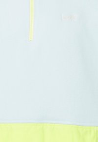 Pullover in fleece blu chiaro con zip a un quarto e orlo verde neon. Presenta un logo sottile in rosa chiaro sul petto. Texture morbida.