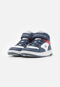 Zapatillas altas de navy hechas de cuero sintético suave, con acentos blancos, dobles tiras de velcro y suelas de goma texturizadas.
