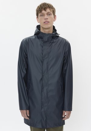 Marineblaue Regenjacke aus wasserdichtem Material, mit Kapuze, Druckknopfverschluss und Seitentaschen, mit einer glatten, glänzenden Textur.