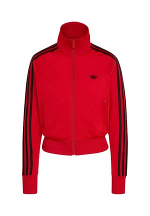 Červená bežecká bunda na zips z hladkého materiálu, s vysokým golierom, dvoma bočnými vreckami a čiernymi pruhmi na rukávoch.