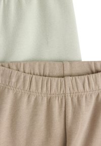 Due pezzi di tessuto: uno verde pallido e uno beige. Entrambi presentano cinture elastiche con una texture arricciata. Materiale liscio e estensibile.