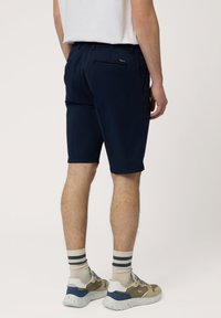 Marineblauwe shorts met een ontspannen pasvorm, gemaakt van lichtgewicht stof. Beschikt over zijzakken en een achterzak met een klein logo detail.