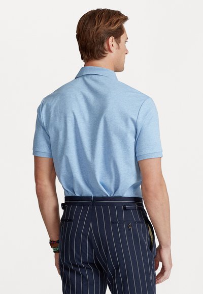 Fényt kék, rövid ujjú pólóing klasszikus gallérral, sötét csíkos nadrággal párosítva, oldalzsebekkel és gomb koszorúkkal.