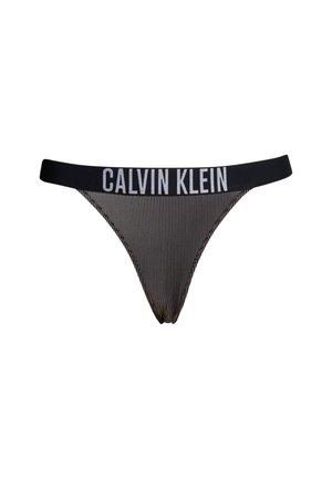 Svart og hvit stripete tanga med bred svart midjebånd som har "CALVIN KLEIN"-logo i hvitt. Glatt stoff med minimalt dekkende design.