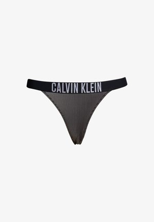 Juodai baltos dryžuotos apatinės kelnaitės su plačiu juodu juostos trikampiu, ant kurio užrašyta "CALVIN KLEIN" balta spalva. Lygus audinys su minimalia aprėptimi.