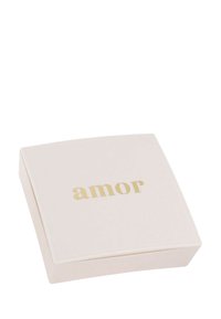 Caja cuadrada de color crema con un acabado suave; texto dorado "amor" en la parte superior; diseño minimalista, bordes ligeramente redondeados.