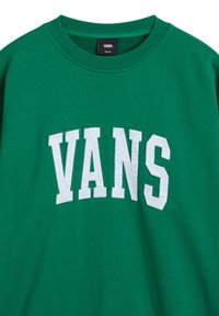 Sudadera verde con cuello redondo, que presenta grandes letras blancas "VANS" en el pecho. Textura de tela suave y etiqueta de tamaño mediano.